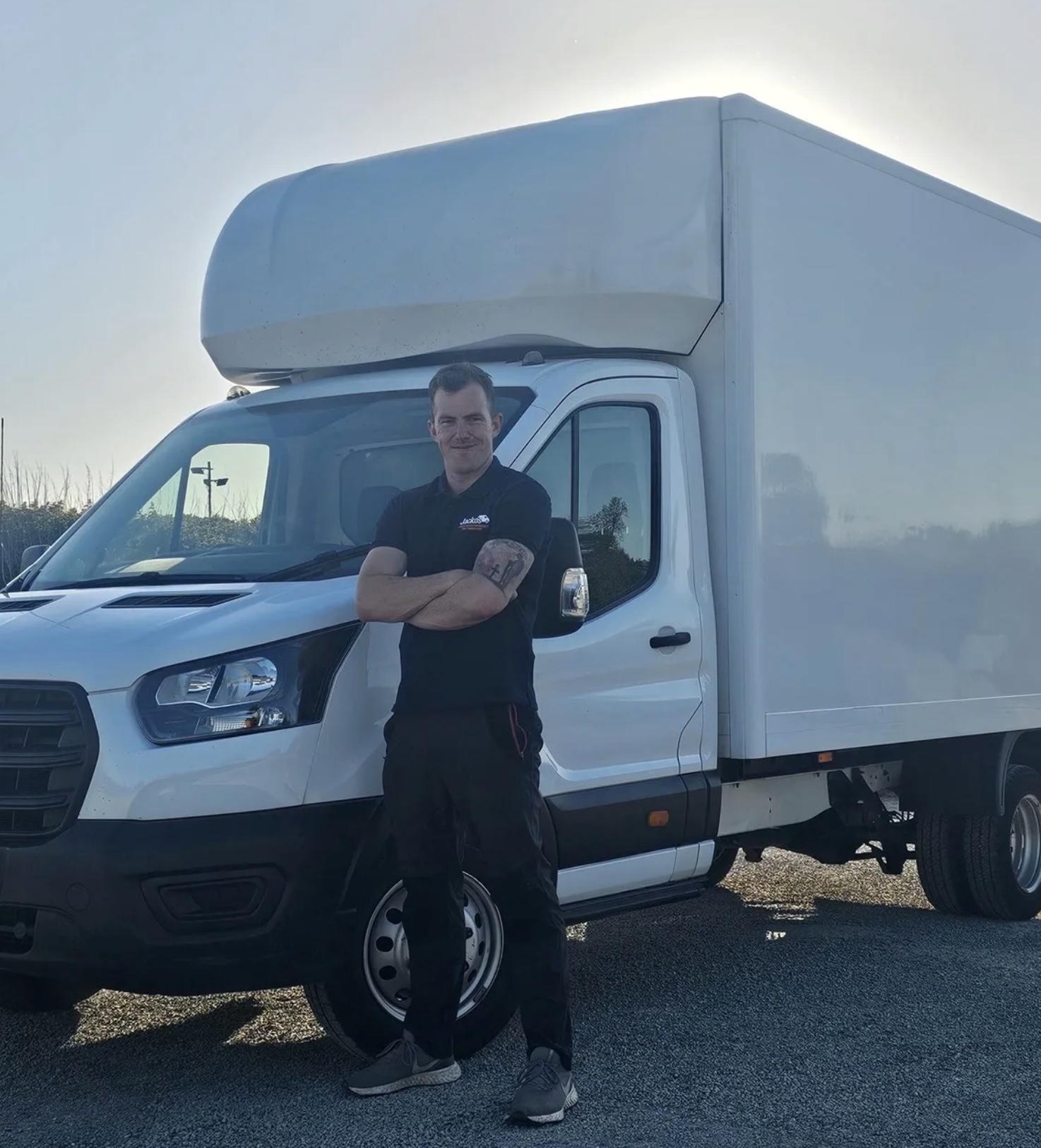 Billy Jackson, founder of Not Just Any Van, standing with his arms folded in front of a white Luton removals van