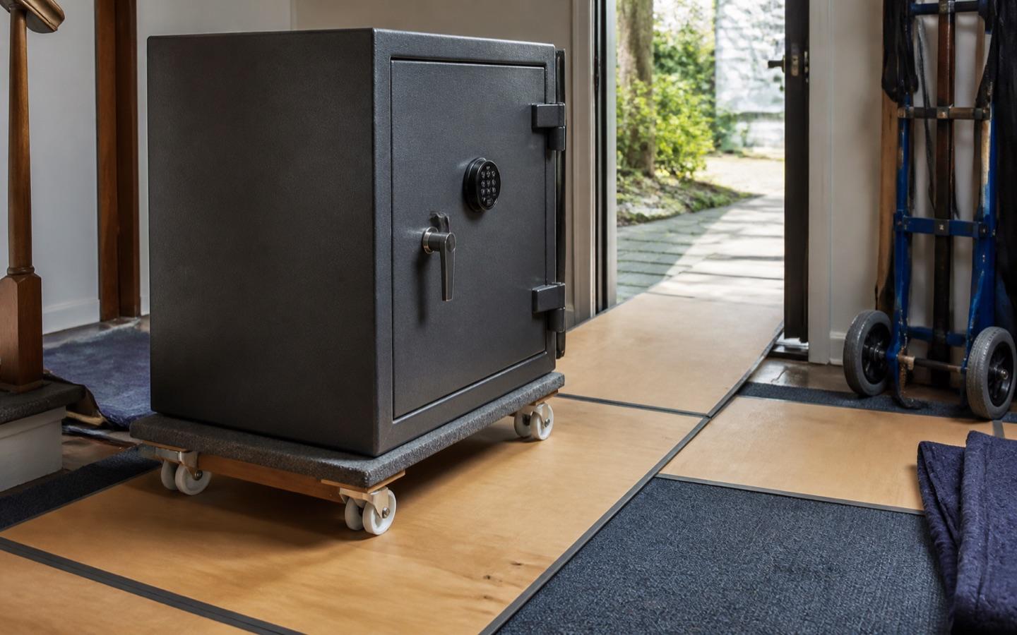 Heavy safe on moving skates with floor protection laid through a doorway